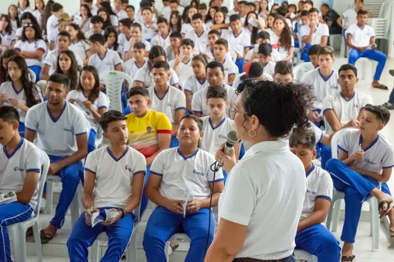 Estudantes uniformizados assistindo a uma apresentação